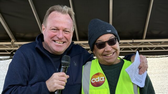 MC Paul Stainton and BSL interpreter Kirsty Dorkenoo in a CDA hi-vis vest smiling together on the main stage at the Great Eastern Run 2026